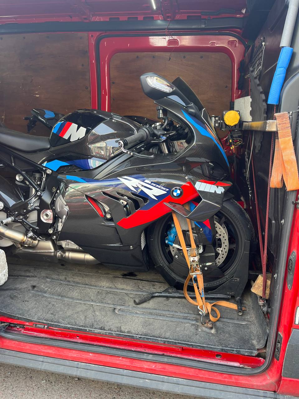 BMW M 1000 RR — гоночний мотоцикл. Видно контури карбонових елементів, передню вилку та заднє підвіску.